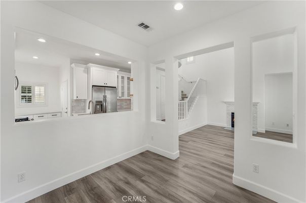 Empty room, Fireplace, Interior, Kitchen, Recessed Lighting, Stainless Steel Appliances, Wood Texture Flooring