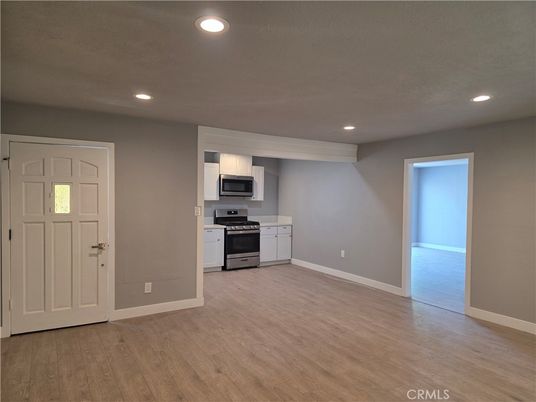 Empty room, Interior, Kitchen, Recessed Lighting, Stainless Steel Appliances, Wood Texture Flooring