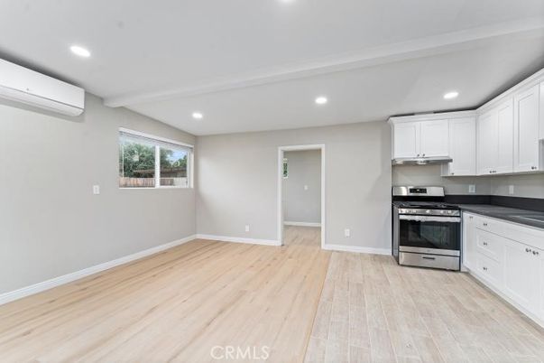 Empty room, Interior, Kitchen, Recessed Lighting, Stainless Steel Appliances, Wood Texture Flooring