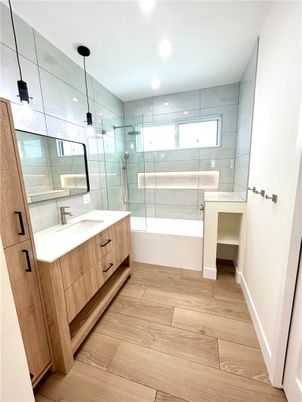 Bathroom, Dual Sink Vanities, Glass Shower, Interior, Marble Walls, Recessed Lighting, Wood Texture Flooring