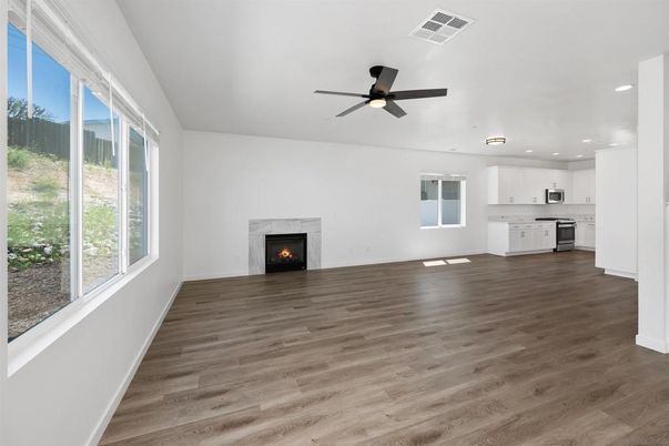 Empty room, Fireplace, Interior, Kitchen, Recessed Lighting, Stainless Steel Appliances, Wood Texture Flooring