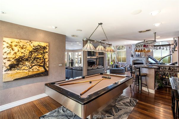Billiard Table, Chandelier, Fireplace, Game Room, Interior, Living room, Pendant Lights, Recessed Lighting, Wood Texture Flooring
