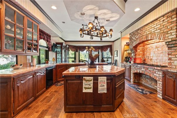Chandelier, Fireplace, Interior, Kitchen, Recessed Lighting, Stone Walls, Tile Countertops, Wood Texture Flooring