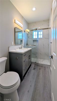 Bathroom, Dual Sink Vanities, Free Standing Baths, Glass Shower, Interior, Marble Walls, Recessed Lighting, Wood Texture Flooring