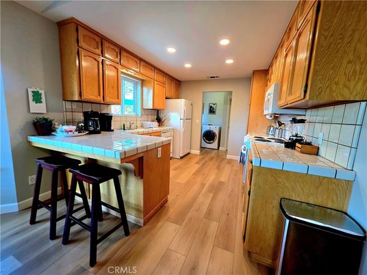 Interior, Kitchen, Recessed Lighting, Tile Countertops, Washer, Wood Texture Flooring