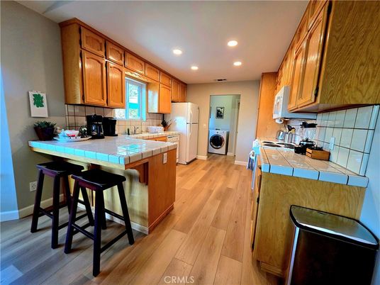 Interior, Kitchen, Recessed Lighting, Tile Countertops, Washer, Wood Texture Flooring