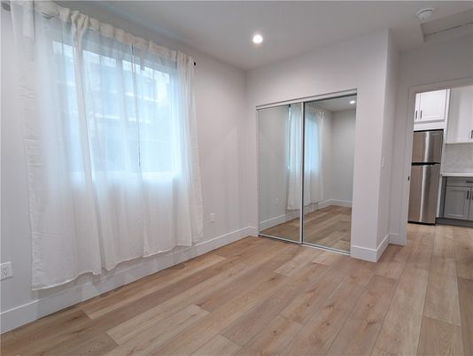 Empty room, Interior, Kitchen, Recessed Lighting, Stainless Steel Appliances, Wood Texture Flooring