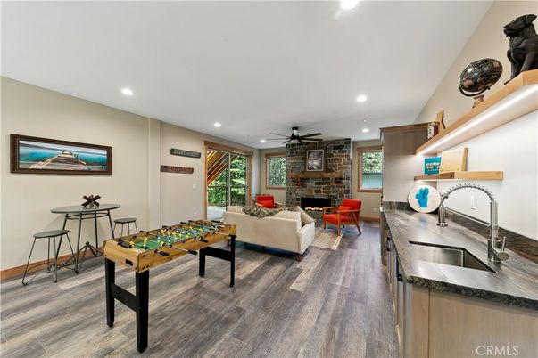 Fireplace, Game Room, Interior, Living room, Recessed Lighting, Stone Walls, Wood Texture Flooring