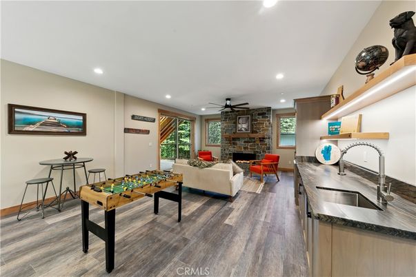 Fireplace, Game Room, Interior, Living room, Recessed Lighting, Stone Walls, Wood Texture Flooring