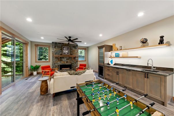 Fireplace, Game Room, Interior, Living room, Recessed Lighting, Stone Walls, Wood Texture Flooring