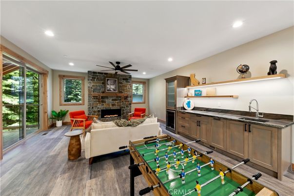 Fireplace, Game Room, Interior, Living room, Recessed Lighting, Stone Walls, Wood Texture Flooring