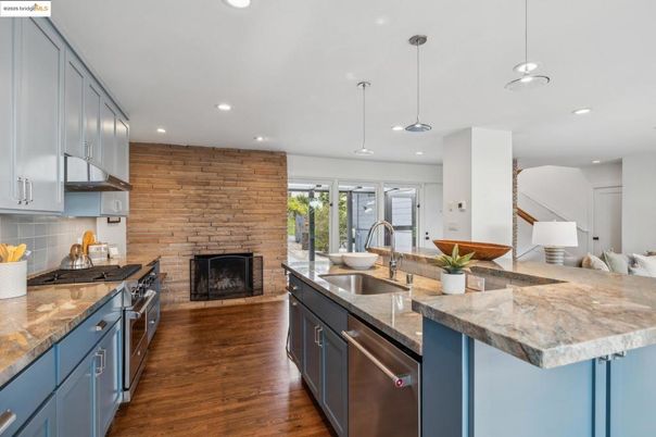 Fireplace, Interior, Kitchen, Pendant Lights, Recessed Lighting, Stainless Steel Appliances, Stone Walls, Wood Texture Flooring