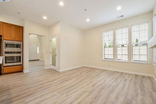 Empty room, Interior, Kitchen, Recessed Lighting, Stainless Steel Appliances, Wood Texture Flooring