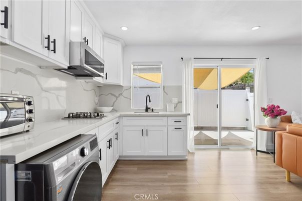 Interior, Kitchen, Marble Walls, Recessed Lighting, Stainless Steel Appliances, Washer, Wood Texture Flooring