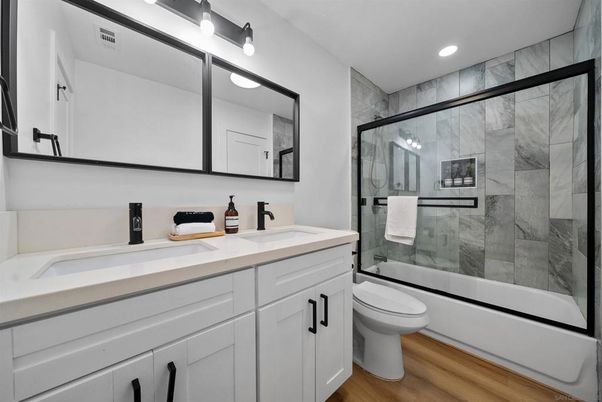 Bathroom, Dual Sink Vanities, Glass Shower, Interior, Marble Walls, Recessed Lighting, Wood Texture Flooring