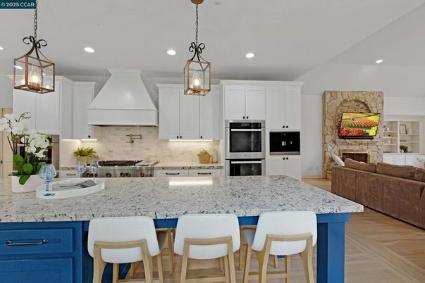 Fireplace, Interior, Kitchen, Pendant Lights, Recessed Lighting, Stainless Steel Appliances, Stone Walls, Wood Texture Flooring