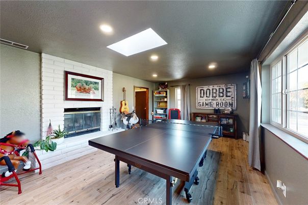 Fireplace, Game Room, Interior, Recessed Lighting, Stone Walls, Wood Texture Flooring