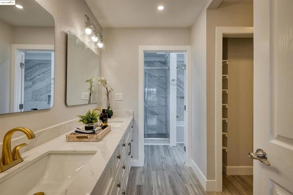 Bathroom, Dual Sink Vanities, Glass Shower, Interior, Marble Walls, Recessed Lighting, Wood Texture Flooring
