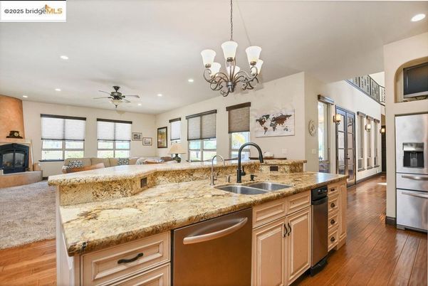 Chandelier, Fireplace, Interior, Kitchen, Living room, Recessed Lighting, Stainless Steel Appliances, Wood Texture Flooring