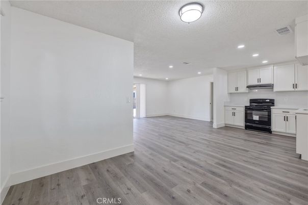 Empty room, Interior, Kitchen, Recessed Lighting, Stainless Steel Appliances, Wood Texture Flooring