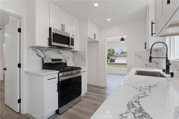 Interior, Kitchen, Marble Walls, Recessed Lighting, Stainless Steel Appliances, Wood Texture Flooring