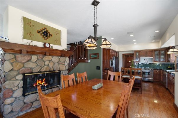 Dining room, Fireplace, Interior, Kitchen, Pendant Lights, Recessed Lighting, Stainless Steel Appliances, Stone Walls, Wood Texture Flooring