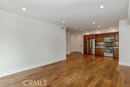 Empty room, Interior, Kitchen, Recessed Lighting, Stainless Steel Appliances, Wood Texture Flooring