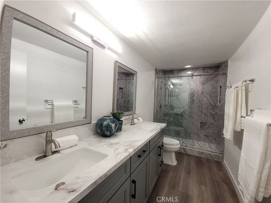 Bathroom, Dual Sink Vanities, Glass Shower, Interior, Marble Walls, Recessed Lighting, Wood Texture Flooring