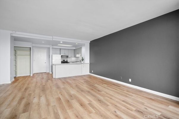 Empty room, Interior, Kitchen, Recessed Lighting, Stainless Steel Appliances, Wood Texture Flooring