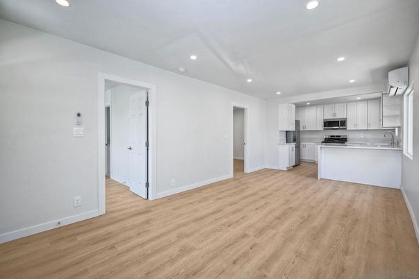 Empty room, Interior, Kitchen, Recessed Lighting, Stainless Steel Appliances, Wood Texture Flooring