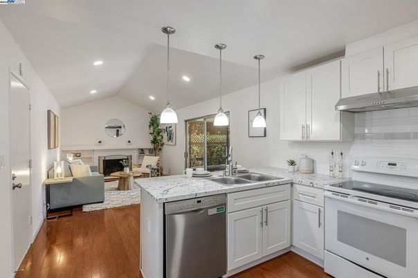 Fireplace, Interior, Kitchen, Living room, Pendant Lights, Recessed Lighting, Stainless Steel Appliances, Wood Texture Flooring