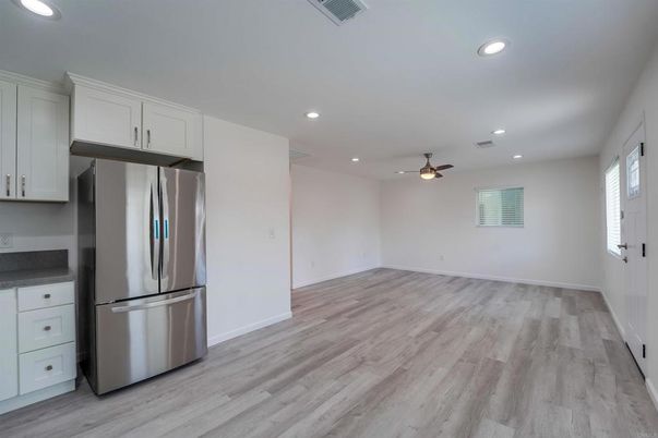 Empty room, Interior, Kitchen, Recessed Lighting, Stainless Steel Appliances, Wood Texture Flooring