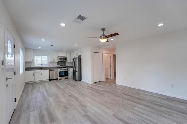 Empty room, Interior, Kitchen, Recessed Lighting, Stainless Steel Appliances, Wood Texture Flooring