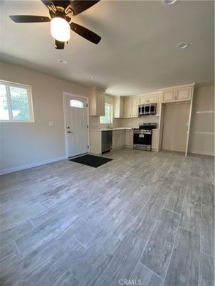Empty room, Interior, Kitchen, Recessed Lighting, Stainless Steel Appliances, Wood Texture Flooring