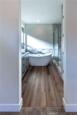 Bathroom, Free Standing Baths, Interior, Marble Walls, Recessed Lighting, Wood Texture Flooring