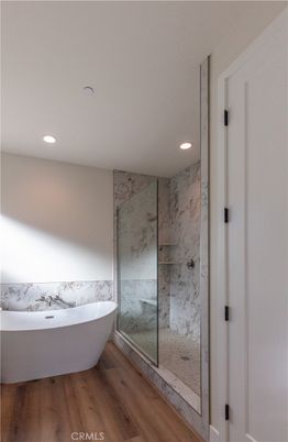 Bathroom, Free Standing Baths, Glass Shower, Interior, Marble Walls, Recessed Lighting, Wood Texture Flooring