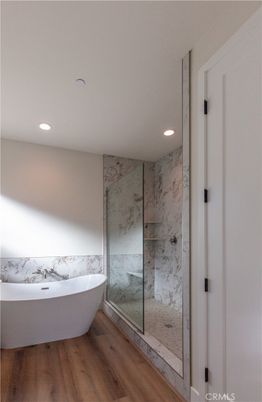 Bathroom, Free Standing Baths, Glass Shower, Interior, Marble Walls, Recessed Lighting, Wood Texture Flooring