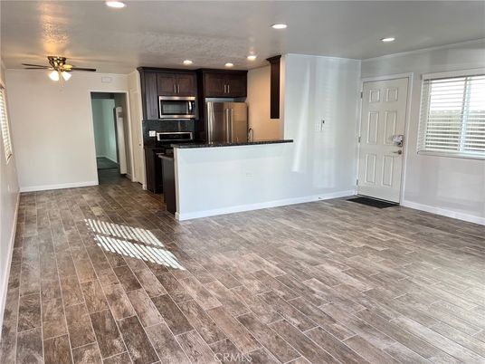 Empty room, Interior, Kitchen, Recessed Lighting, Stainless Steel Appliances, Wood Texture Flooring