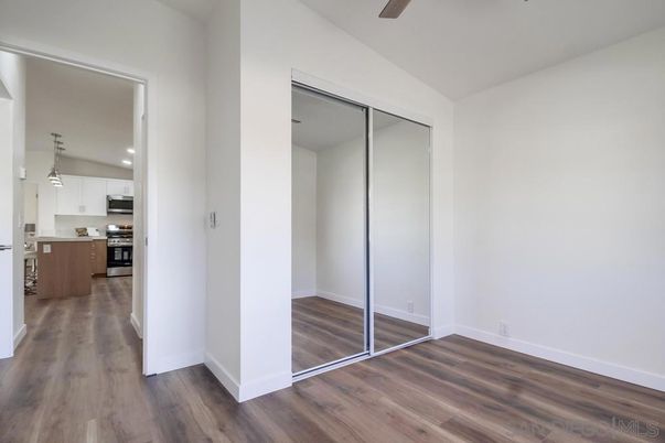 Empty room, Interior, Kitchen, Pendant Lights, Recessed Lighting, Stainless Steel Appliances, Wood Texture Flooring