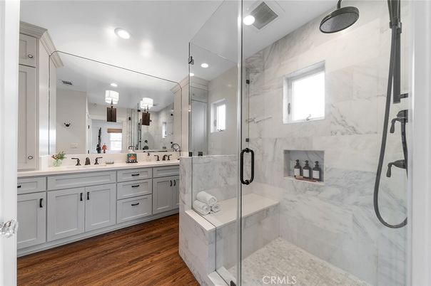 Bathroom, Dual Sink Vanities, Glass Shower, Interior, Marble Walls, Recessed Lighting, Wood Texture Flooring