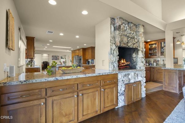 Fireplace, Interior, Kitchen, Pendant Lights, Recessed Lighting, Stainless Steel Appliances, Stone Walls, Wood Texture Flooring