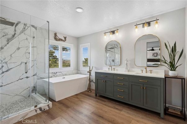Bathroom, Dual Sink Vanities, Free Standing Baths, Glass Shower, Interior, Marble Walls, Recessed Lighting, Wood Texture Flooring