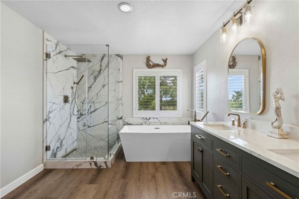 Bathroom, Dual Sink Vanities, Free Standing Baths, Glass Shower, Interior, Marble Walls, Recessed Lighting, Wood Texture Flooring