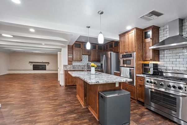 Fireplace, Interior, Kitchen, Pendant Lights, Recessed Lighting, Stainless Steel Appliances, Stone Walls, Wood Texture Flooring