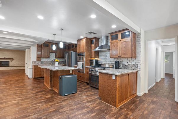 Fireplace, Interior, Kitchen, Pendant Lights, Recessed Lighting, Stainless Steel Appliances, Stone Walls, Wood Texture Flooring