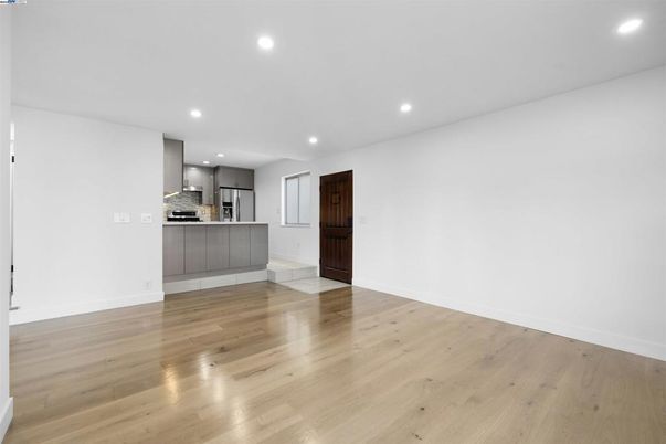 Empty room, Interior, Kitchen, Recessed Lighting, Stainless Steel Appliances, Wood Texture Flooring