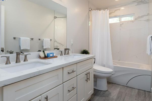 Bathroom, Dual Sink Vanities, Glass Shower, Interior, Marble Walls, Recessed Lighting, Wood Texture Flooring