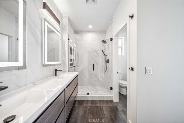 Bathroom, Dual Sink Vanities, Glass Shower, Interior, Marble Walls, Recessed Lighting, Wood Texture Flooring