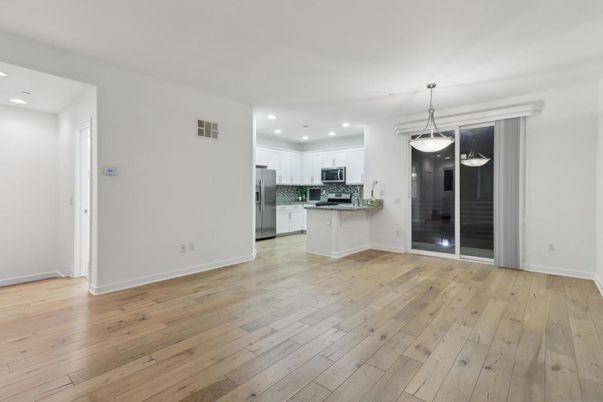 Empty room, Interior, Kitchen, Pendant Lights, Recessed Lighting, Stainless Steel Appliances, Wood Texture Flooring