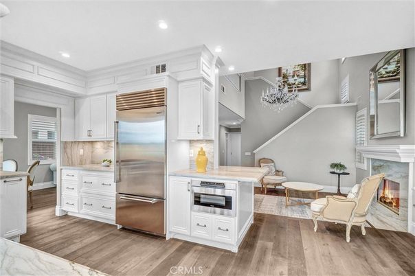 Chandelier, Fireplace, Interior, Kitchen, Recessed Lighting, Stainless Steel Appliances, Wood Texture Flooring